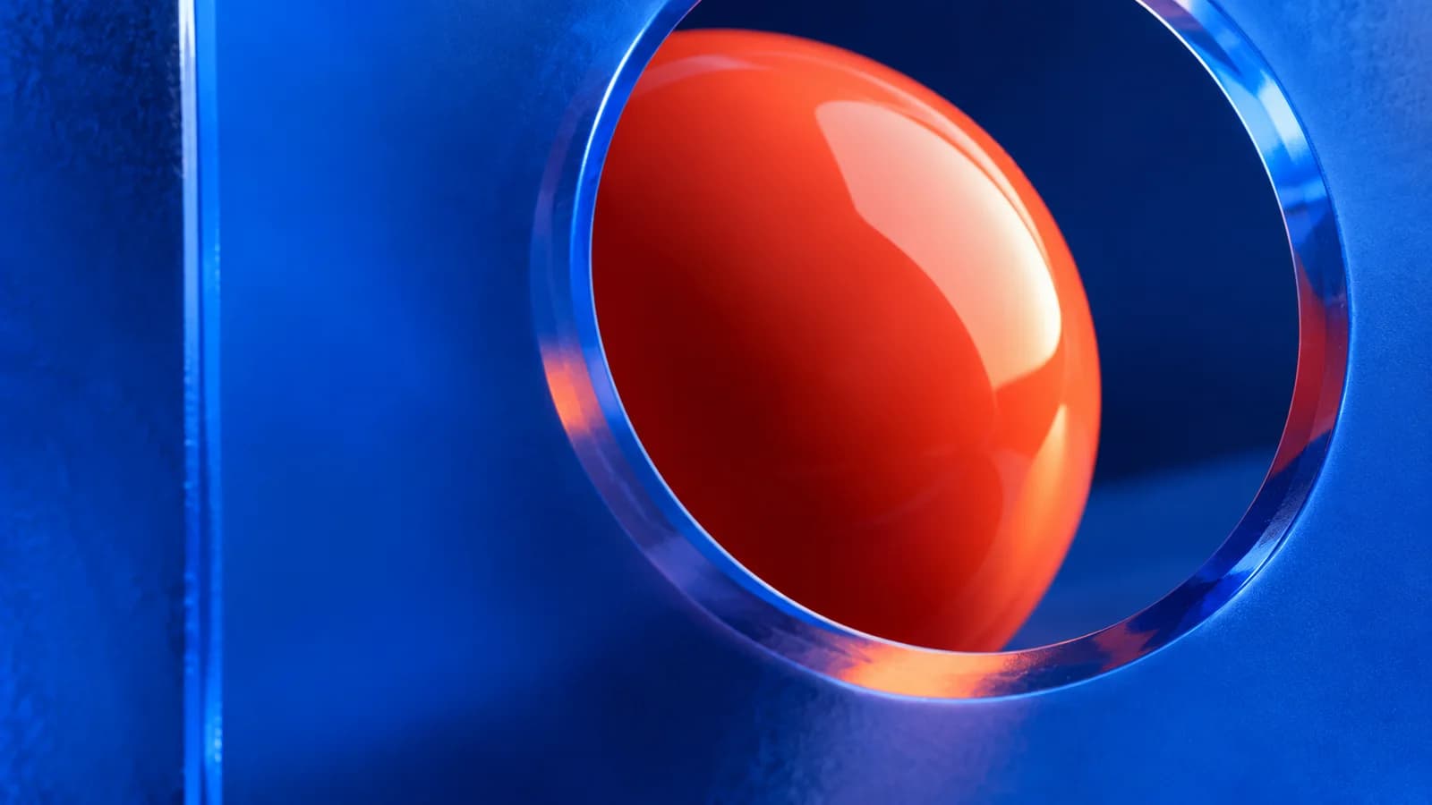 A coral-red sphere seen through a circular opening in electric-blue acrylic