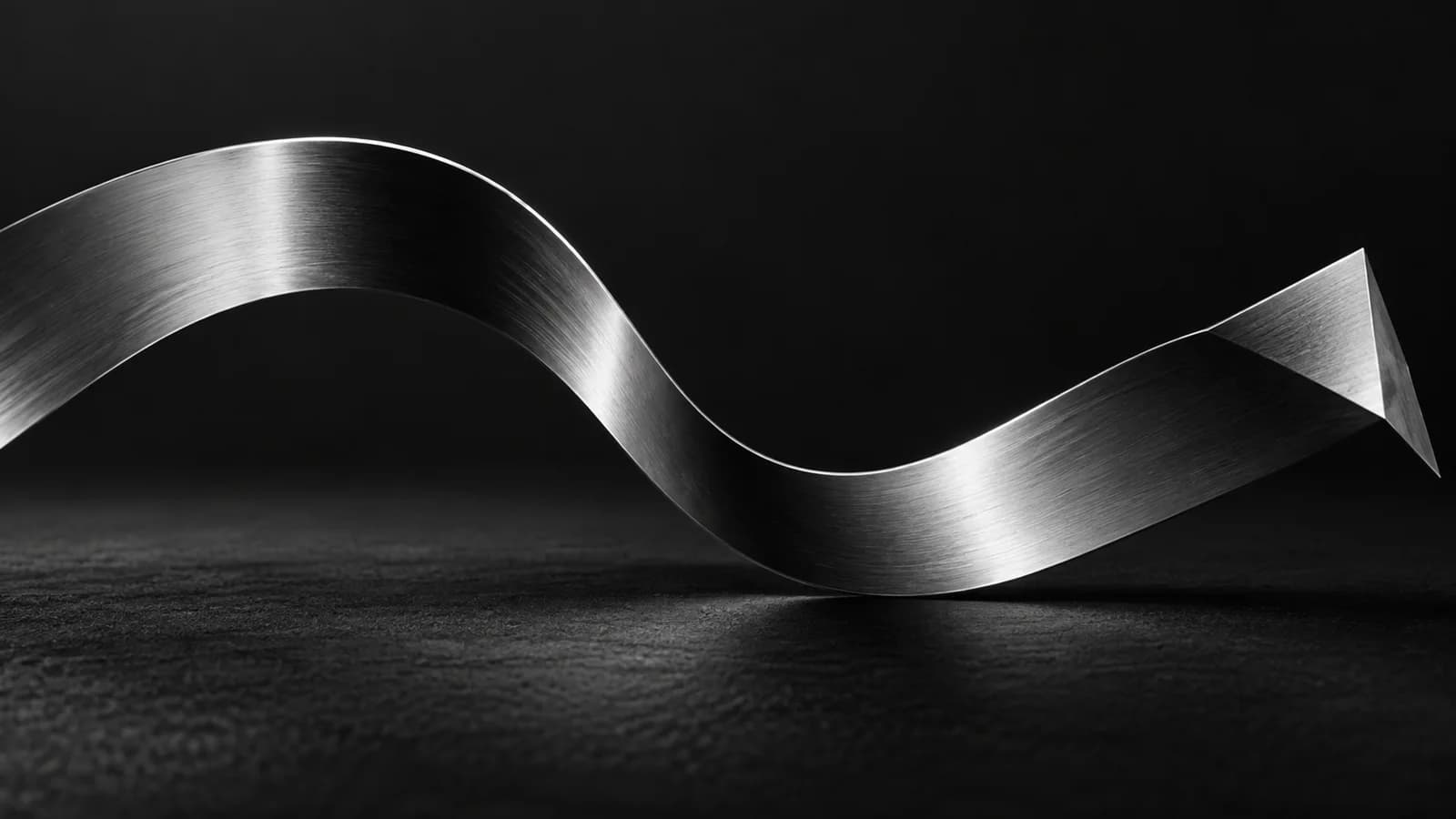 A brushed-chrome ribbon traces a continuous silver curve over matte charcoal