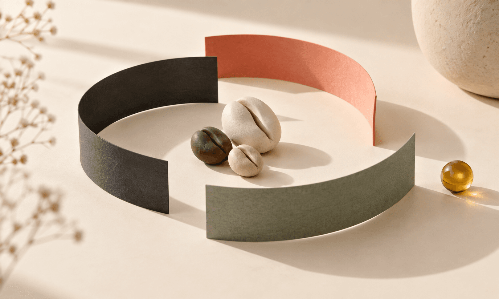 Coral, sage and charcoal paper forms arranged as a calm editorial still life