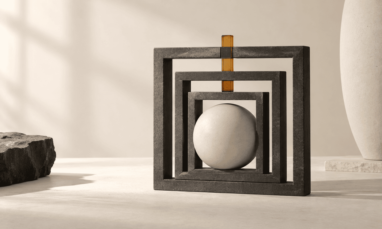 Nested charcoal frames surround an ivory sphere with an amber alignment peg