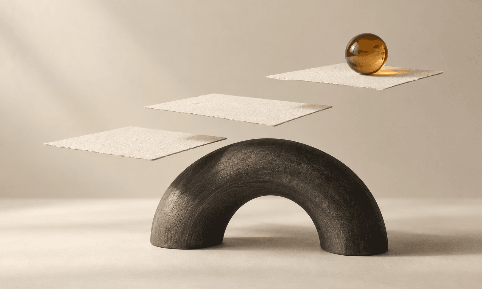 Ivory paper steps rise above a charcoal arch toward an amber sphere