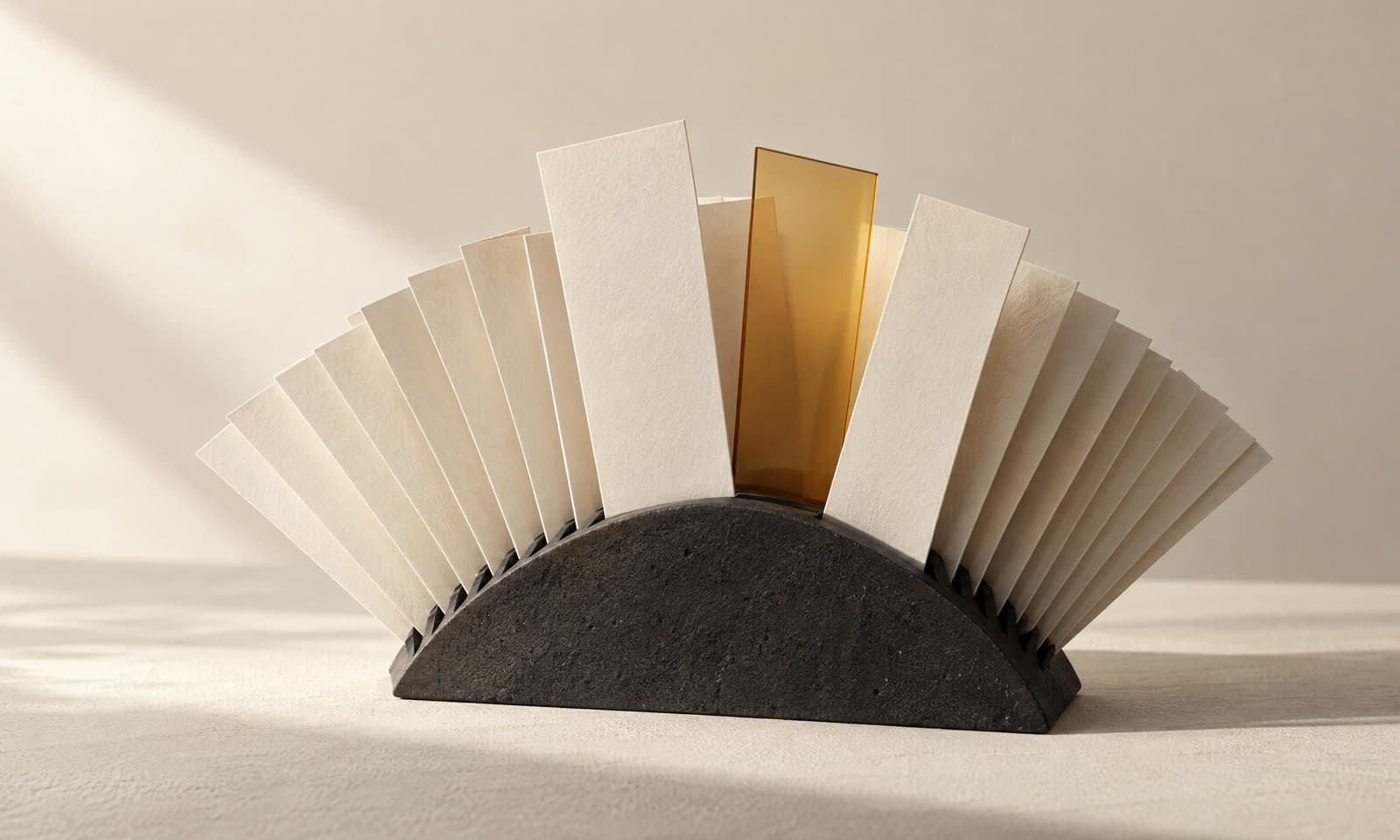 A charcoal fan-shaped rack holding many thin ivory paper slips with three pulled forward and one amber glass slip among them