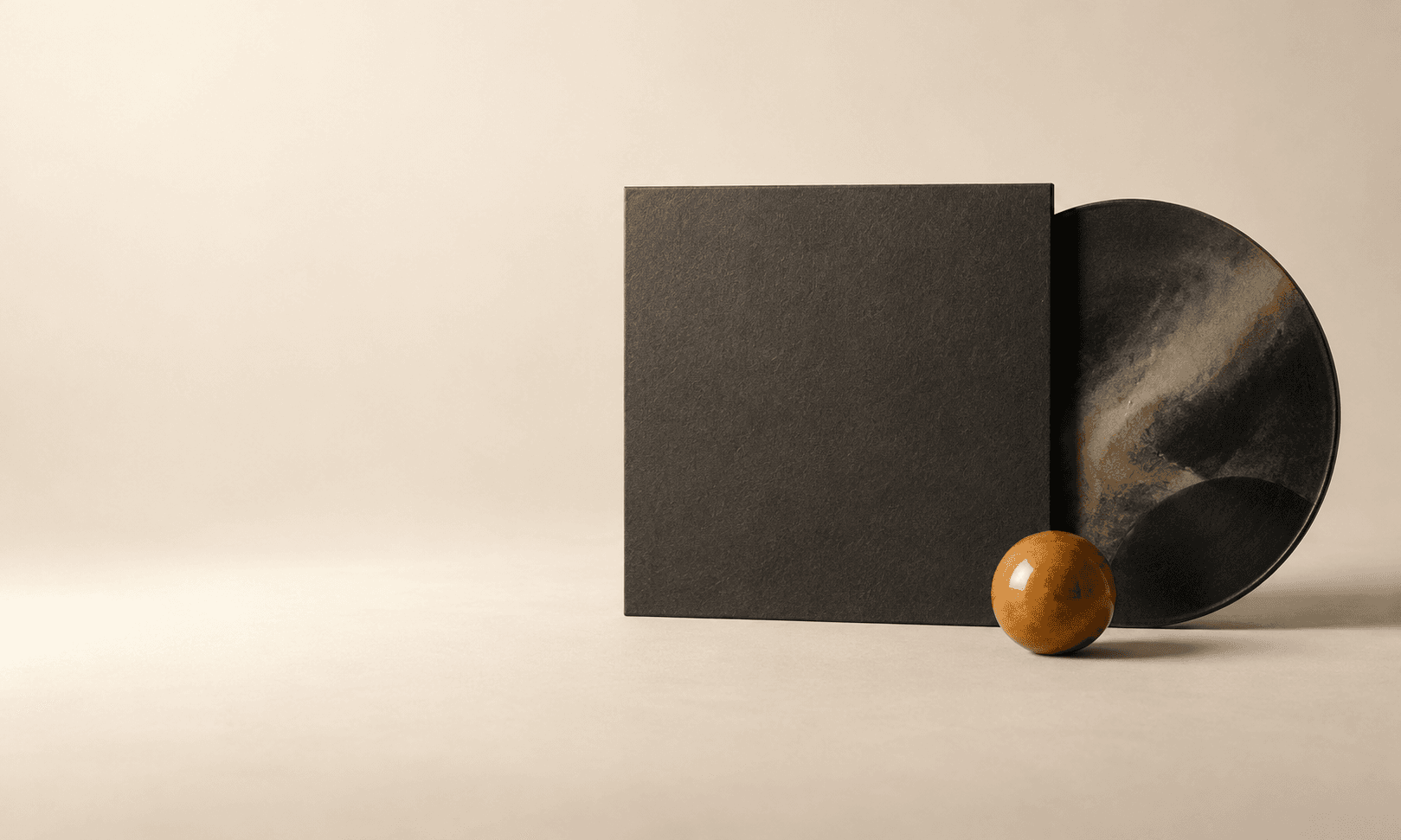 A blank charcoal square sleeve and ceramic disc with a small amber sphere