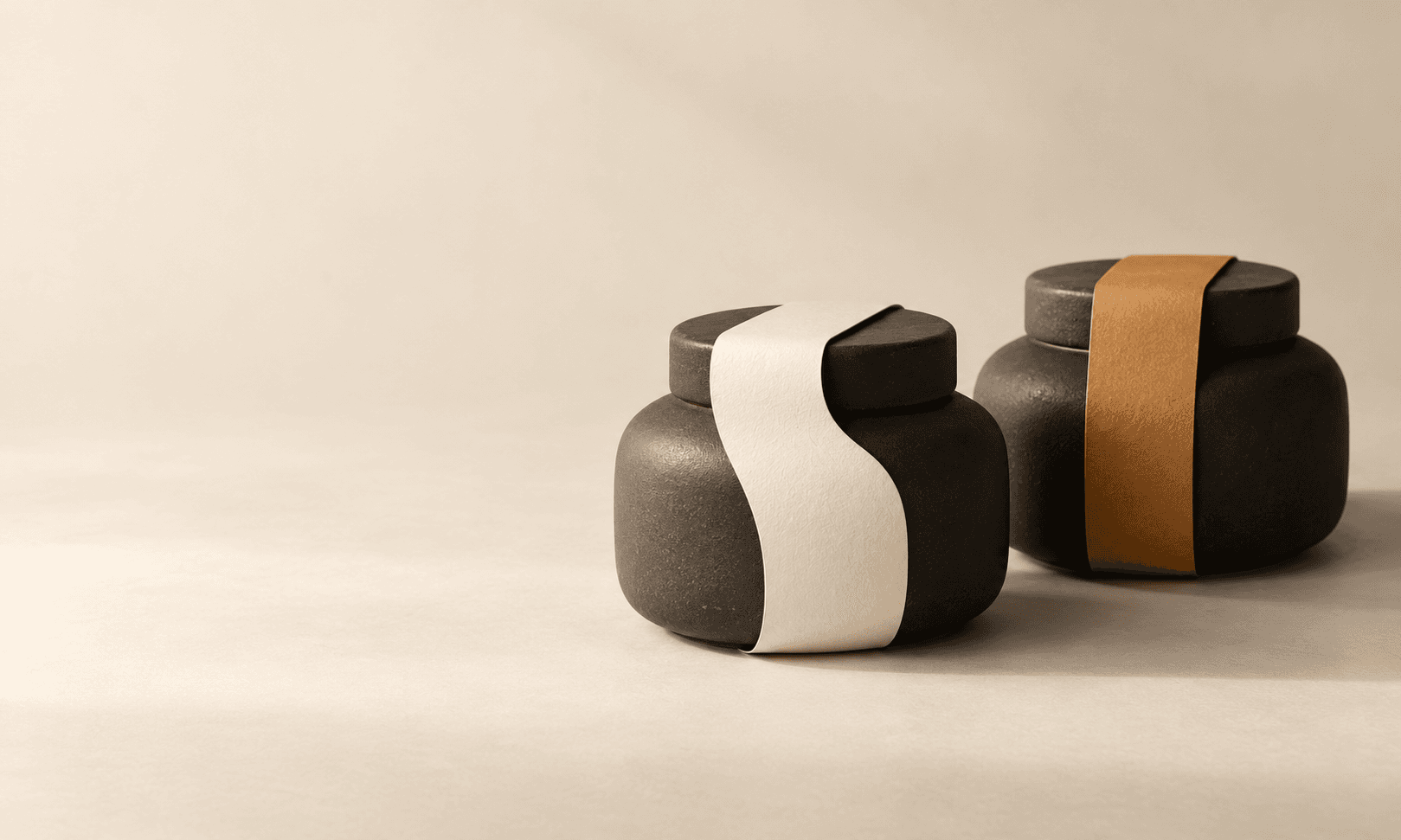 Two charcoal ceramic jars wrapped with blank ivory and amber paper bands