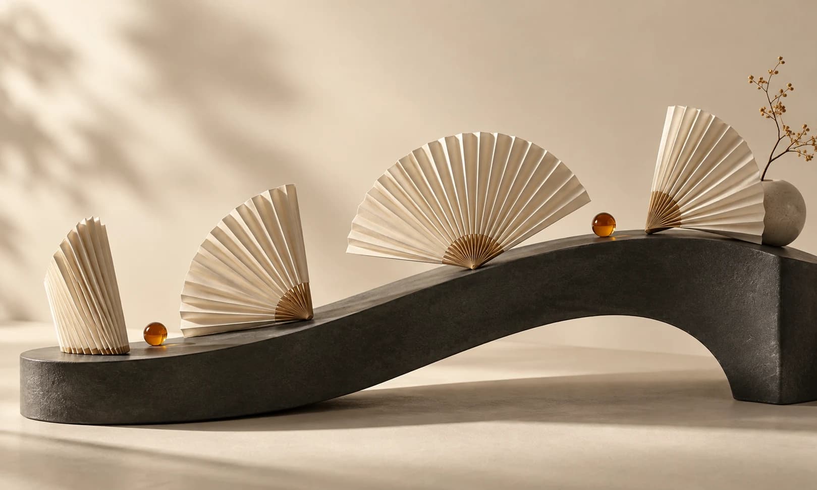 Ivory folded fans at different openings on a charcoal curved plinth