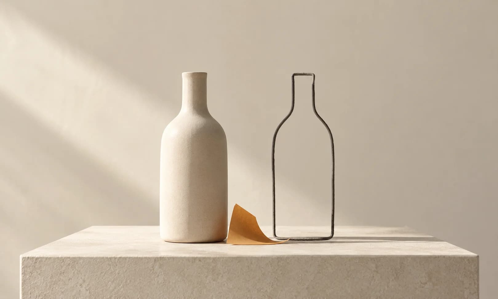 An ivory bottle stands beside a wire outline of the same silhouette.
