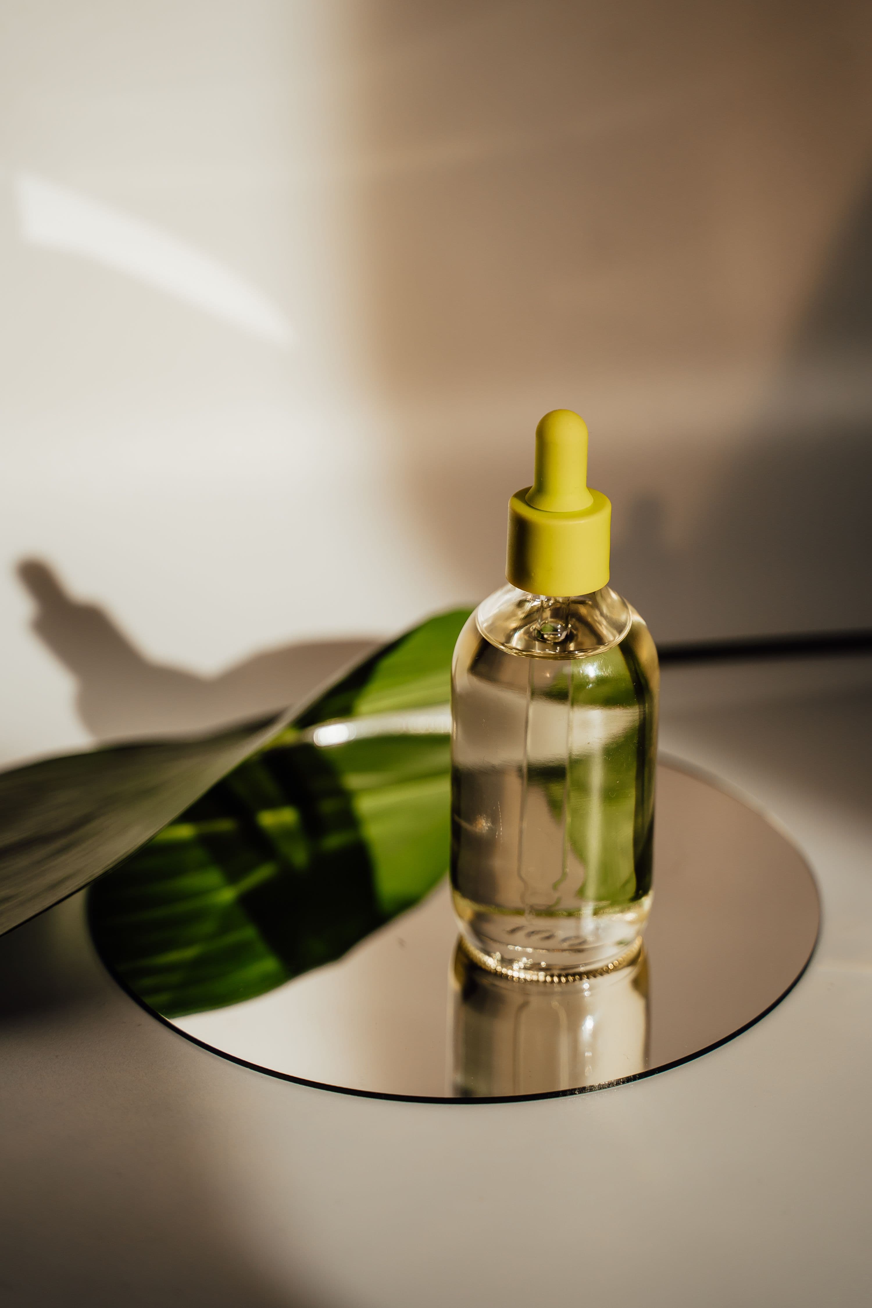 Dropper bottle photographed beside a leaf