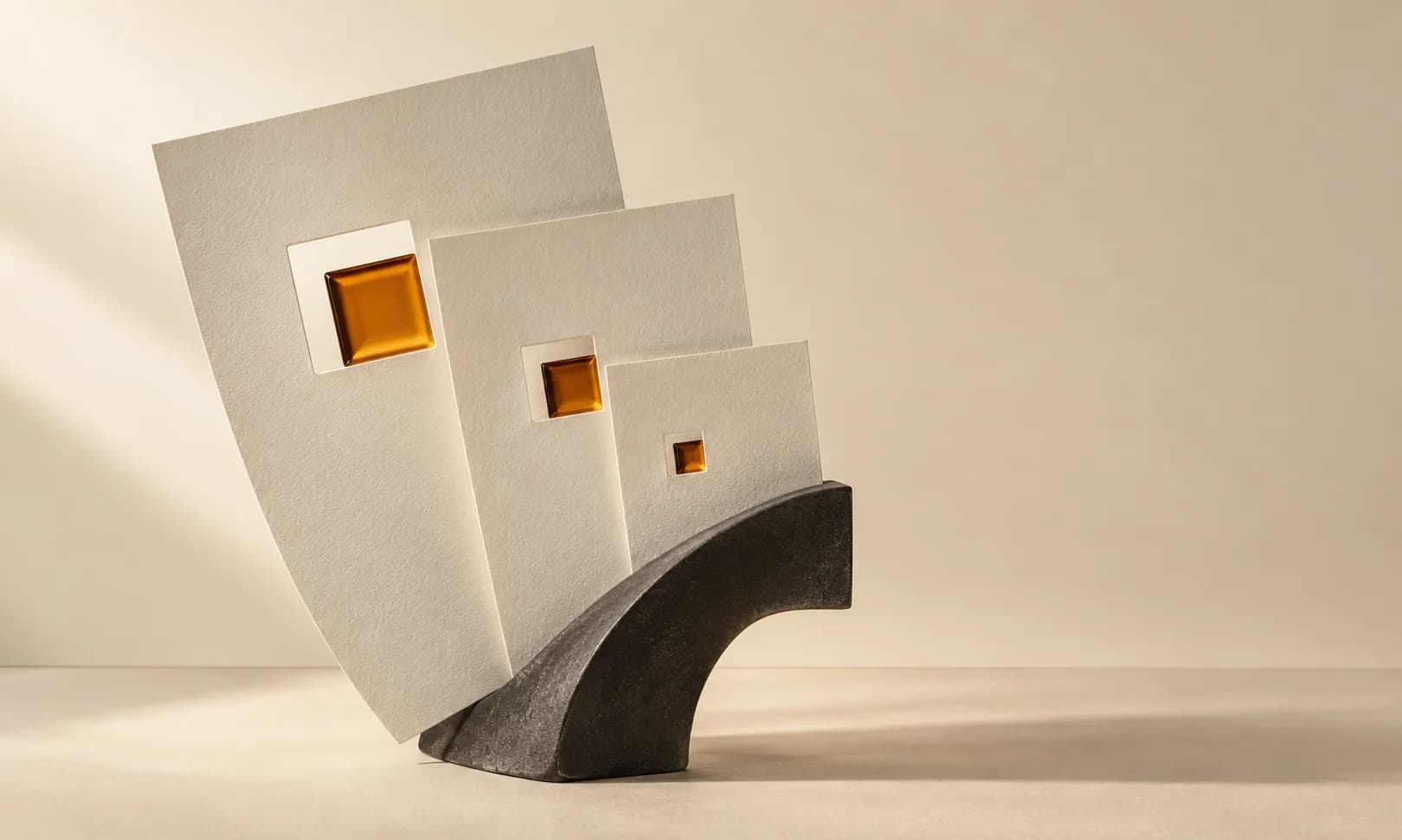 Ivory paper formats held by a charcoal bracket, with matching amber insets.