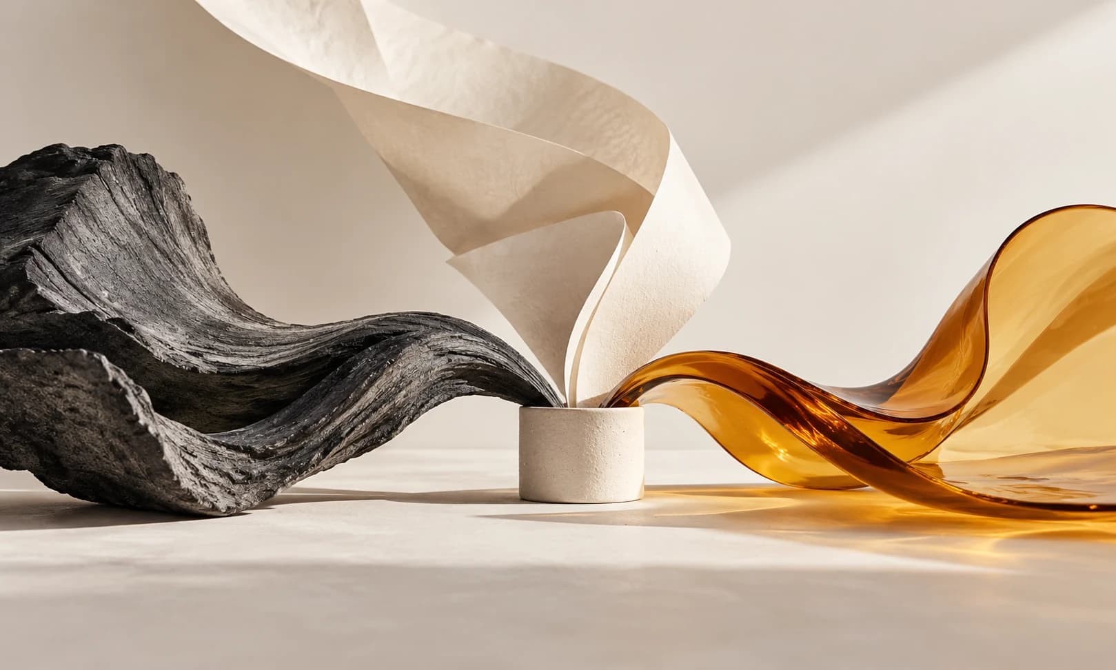 Three sculptural paths converge around a small ceramic form.